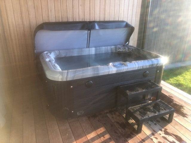 Sensation Azure 4 Person Spa Pool with cover on wooden deck.