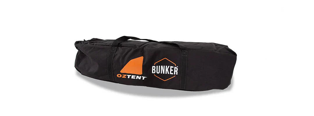 Oztent Bunker Pro Stretcher Bed in black carry bag with logo.