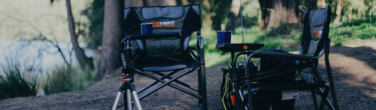 Oztent Gecko Chair with side table set up in a natural outdoor setting.