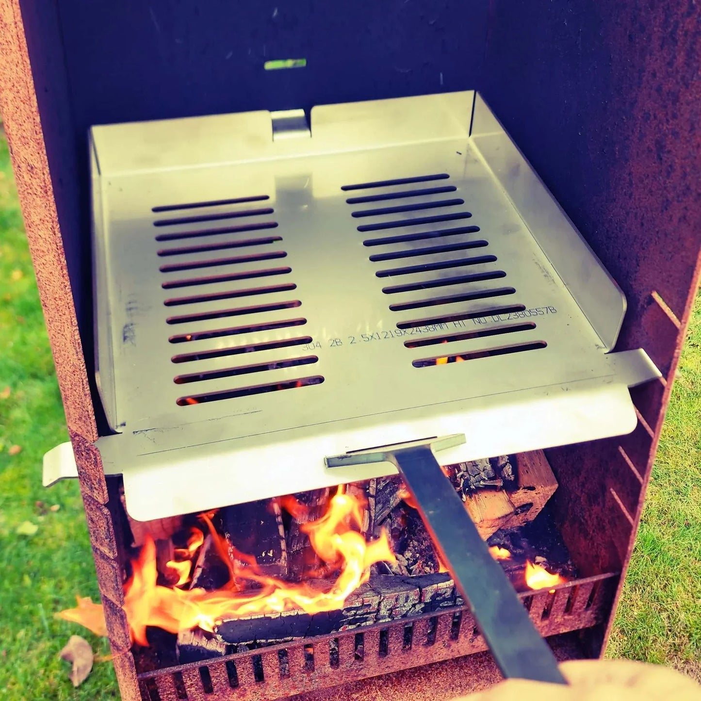 Pizza kit for Obelisk outdoor fire with stainless steel rack, pizza stone, and peel.