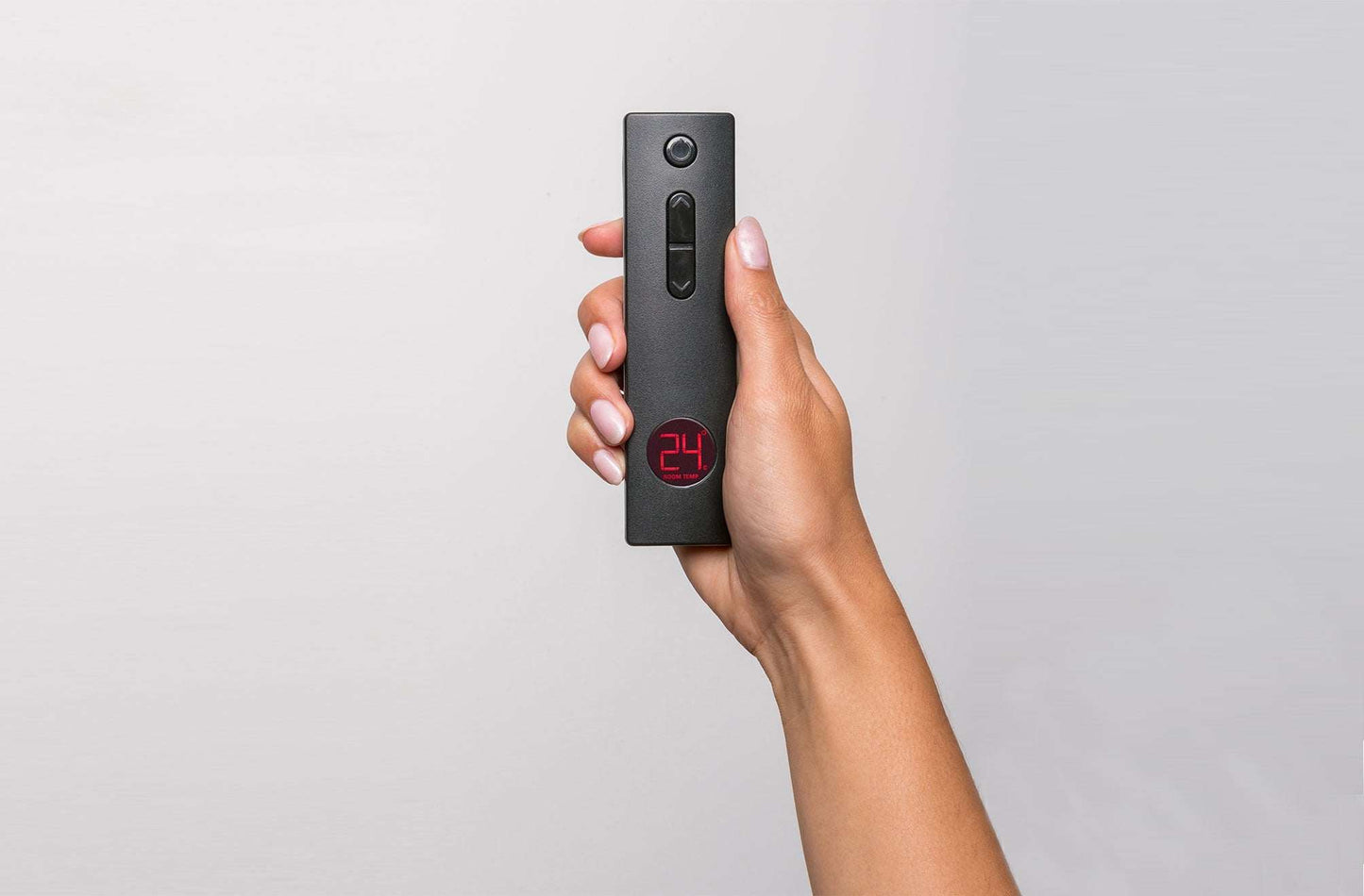 Hand holding a Rinnai Linear 800 remote with digital temperature display.