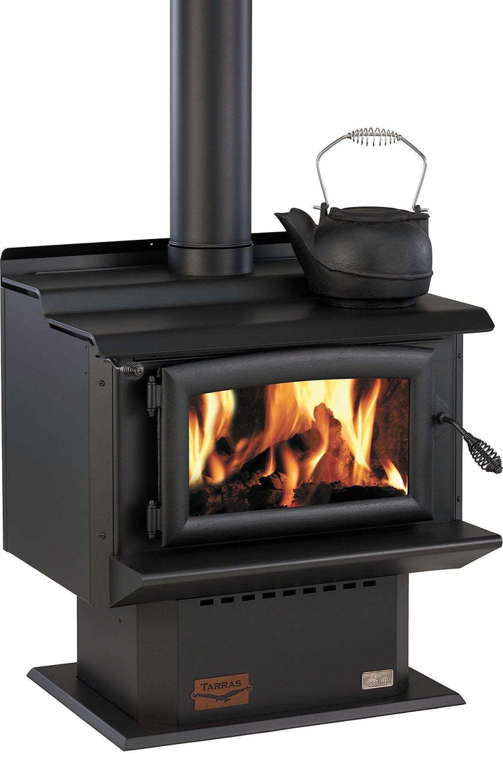 Woodsman Tarras MKIII fireplace with flue system, featuring flames and cast iron door.