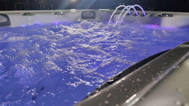 Sensation Euphoria 5.9m Pro Swim Spa with illuminated water jets and bubbling water, perfect for relaxation and exercise.