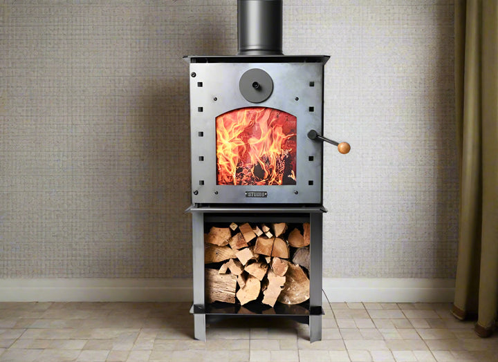 Warmington NAKED Studio 14 woodburner with flue system, featuring a burning fire and wood storage.