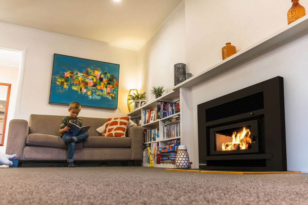 Children playing in a cozy living room with the Woodsman Totara Insert Fireplace providing warmth and ambience.