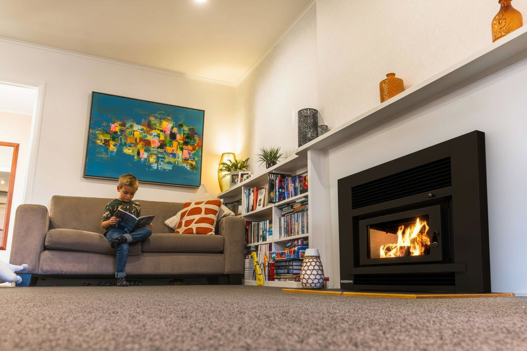 Children playing in a cozy living room with the Woodsman Totara Insert Fireplace providing warmth and ambience.