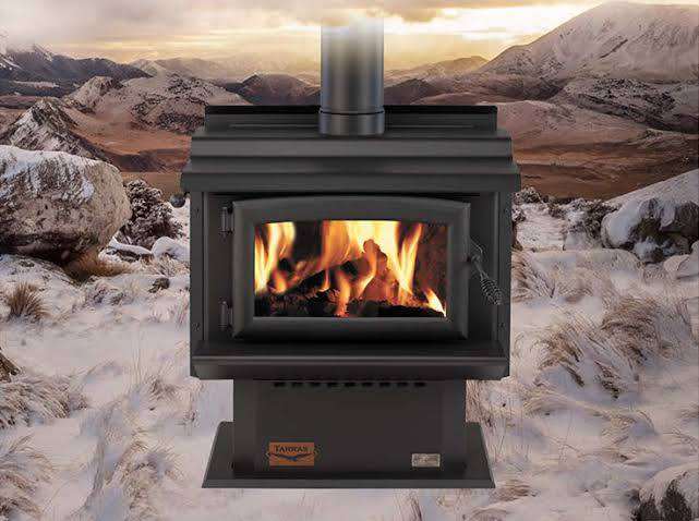 Woodsman Tarras MKIII fireplace with Wetback and 4.2m Heatsaver Flue System in a rustic setting.