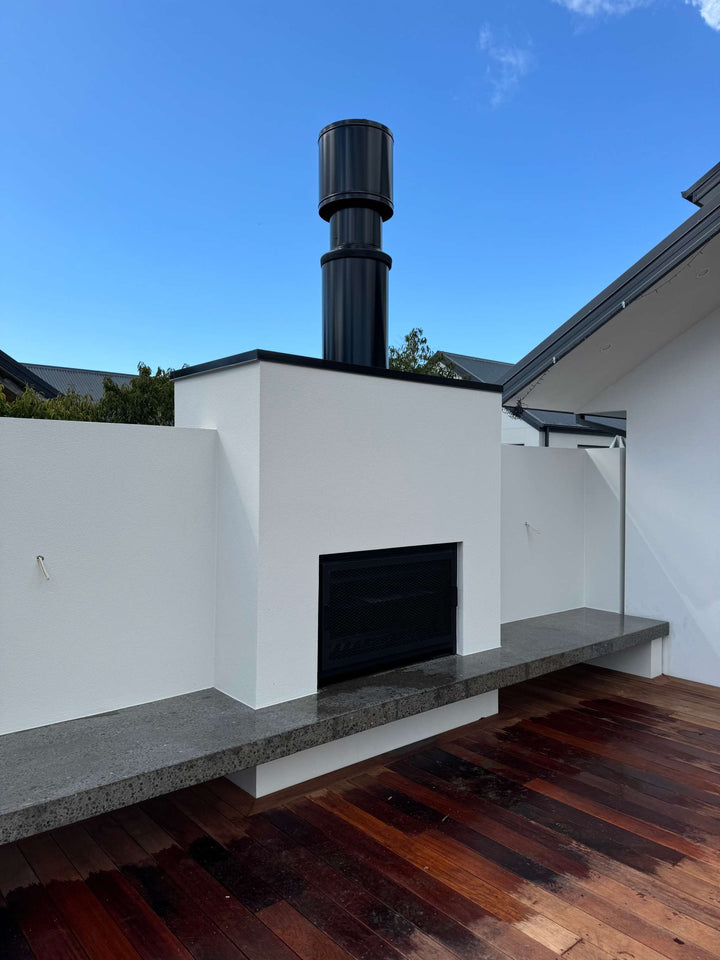 Onflame 1200 outdoor fireplace with 1.5m flue system in a modern patio setting.